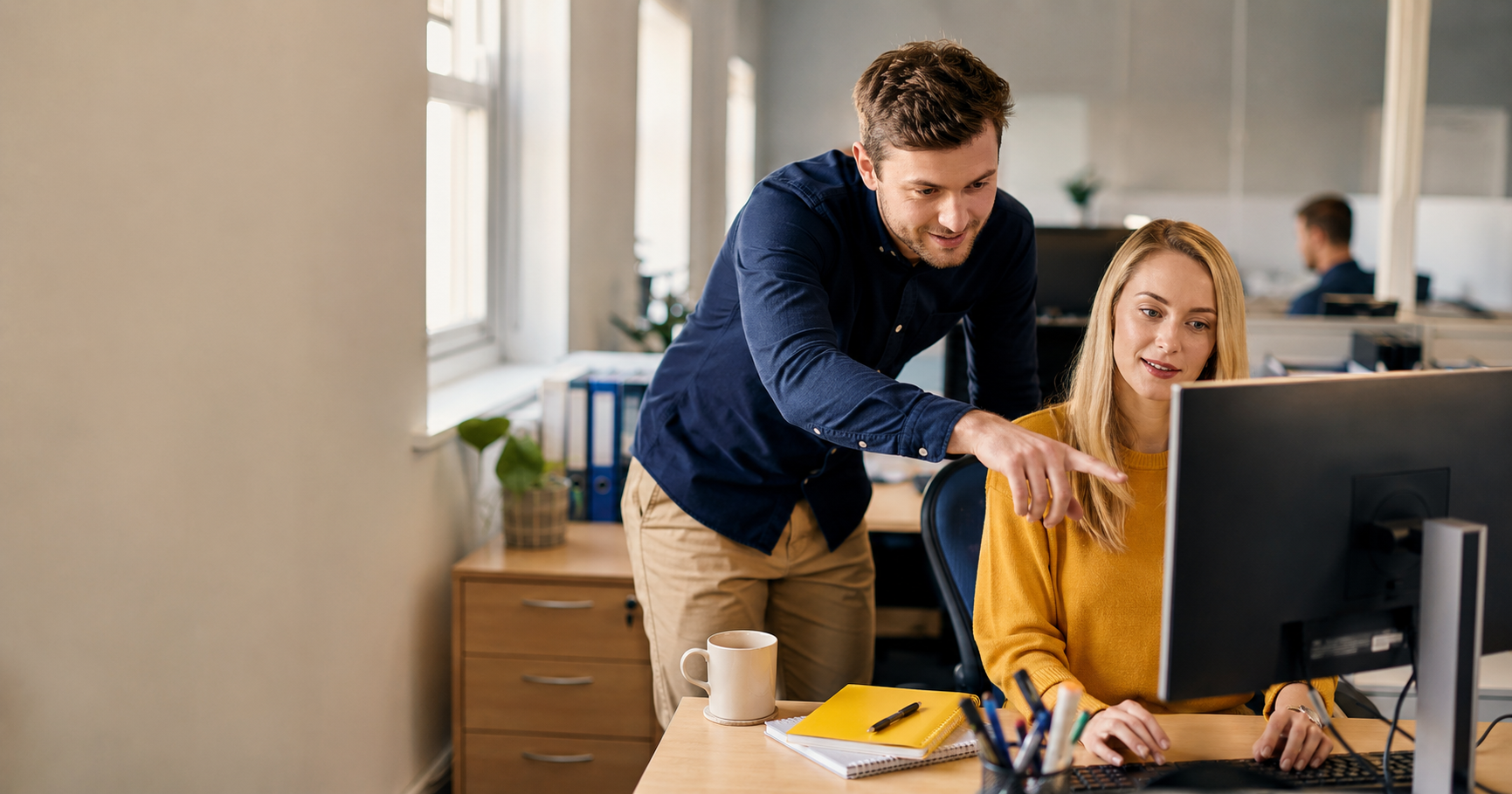 Apprentice showing a colleague an automated workflow during the Level 4 AI and Automation Practitioner apprenticeship